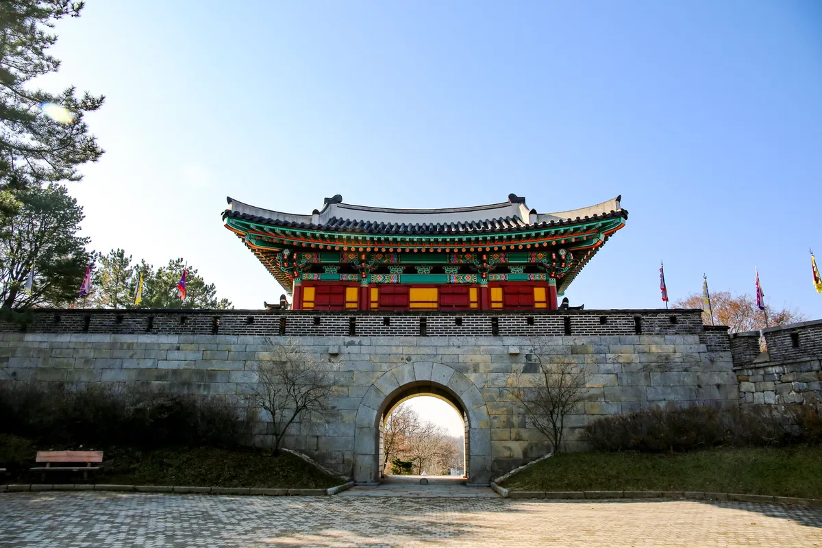 A beautiful traditional Korean fortress gate in Incheon, showcasing colorful architecture under a clear blue sky.