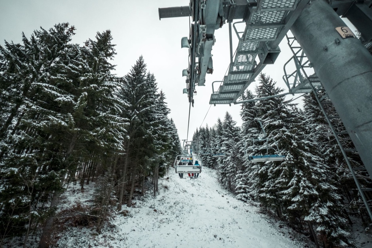 A physical ski lift ticket pass against a backdrop of fresh powder snow.